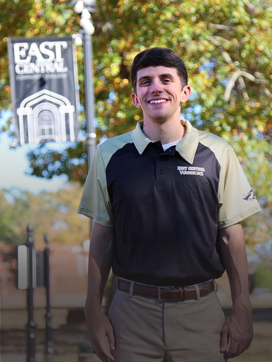 Portrait of Ben Pace with dark hair wearing ECCC polo