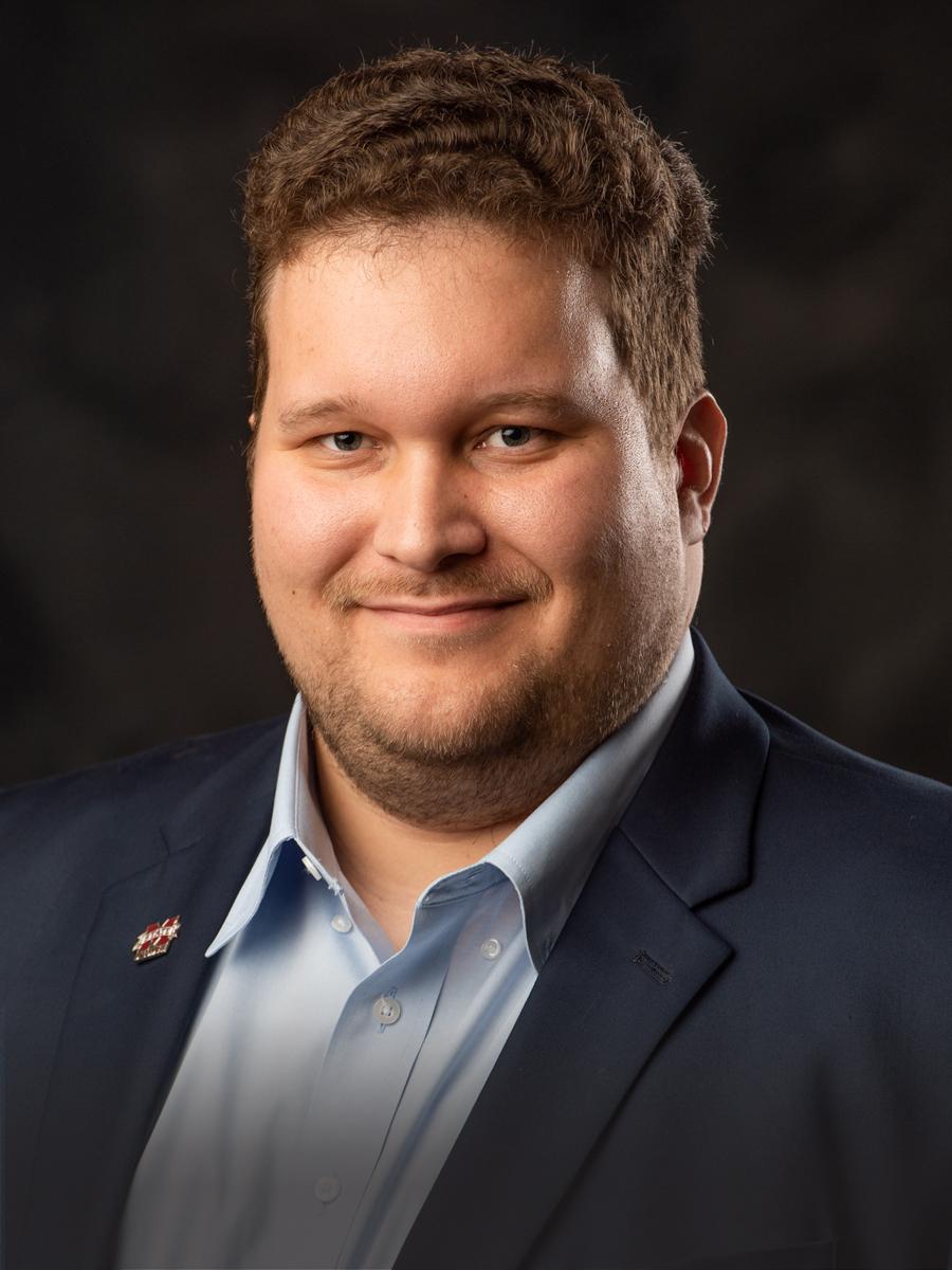 Portrait of Matthew Blackwell with short brown hair wearing a blue button down and a blue blazer.